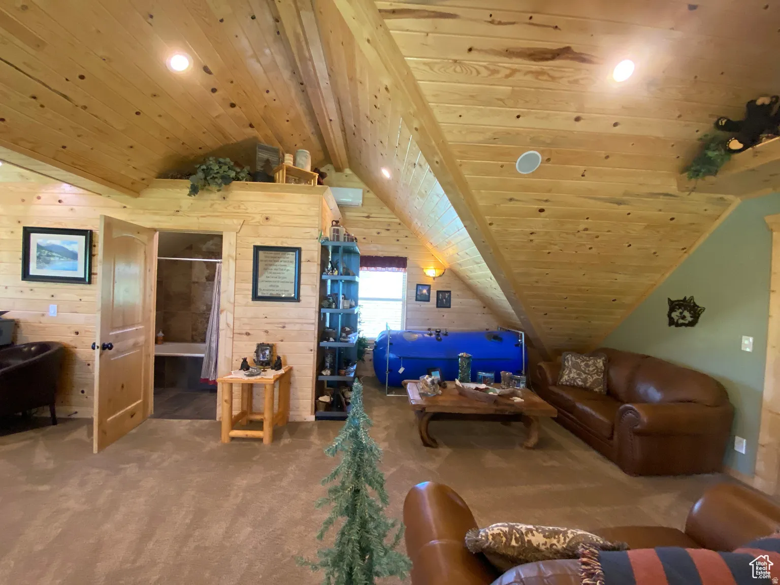 Living area featuring a wood ceiling with exposed beams, carpet, wood walls, and recessed lighting