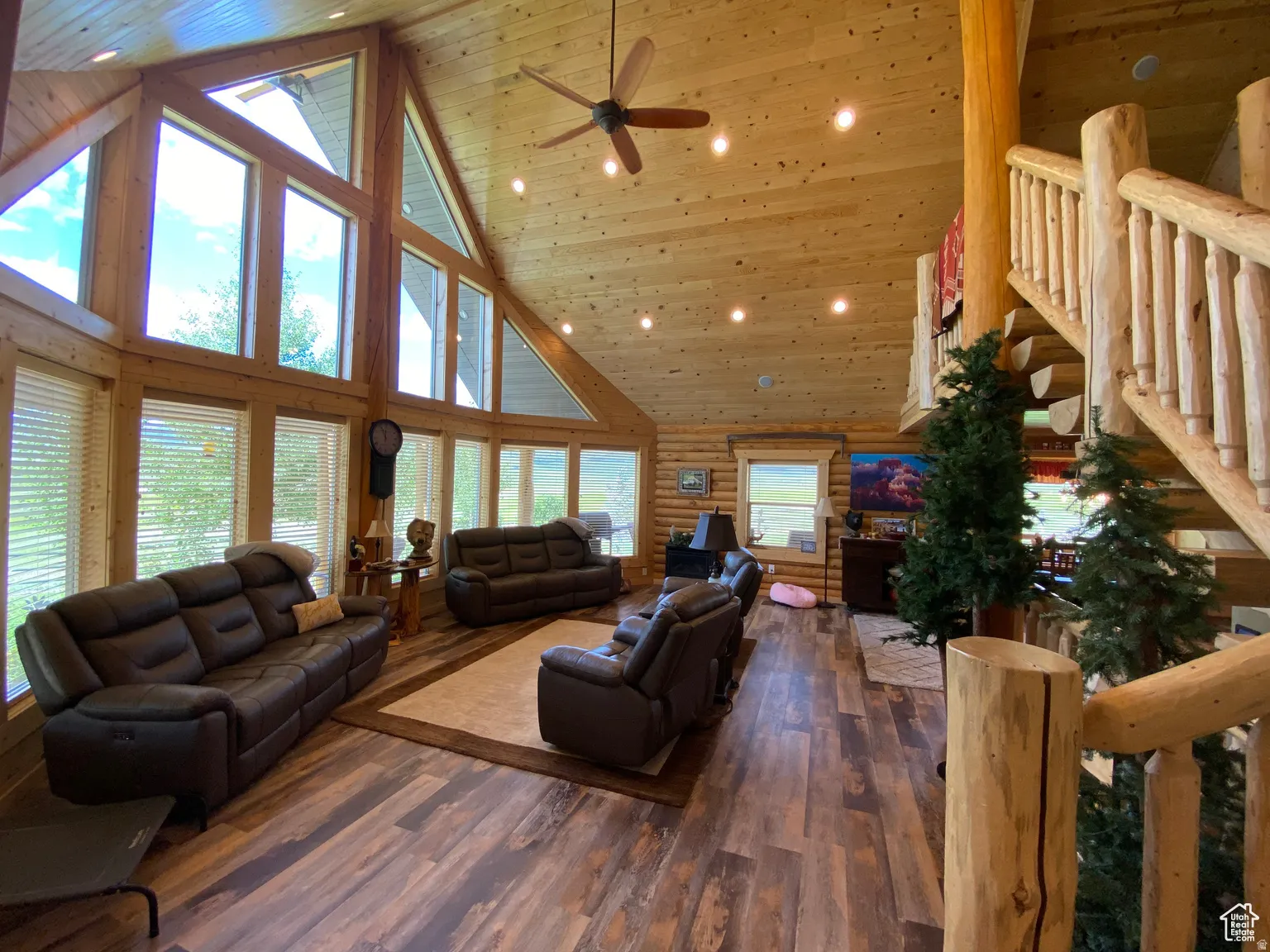 Living room with log walls, a ceiling fan, a vaulted wood ceiling, dark wood-type flooring, and recessed lighting