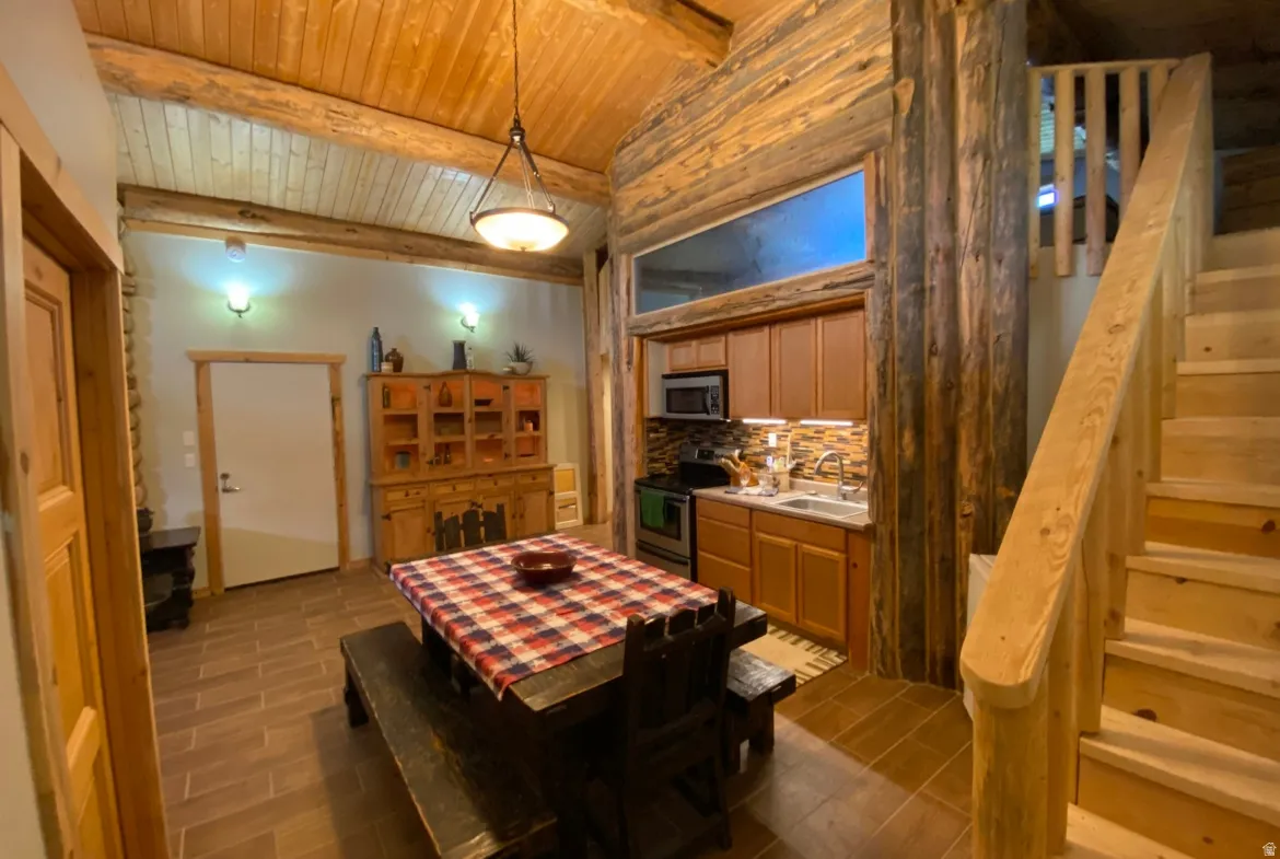 Dining space featuring a wooden ceiling with exposed beams and wood tiled floors