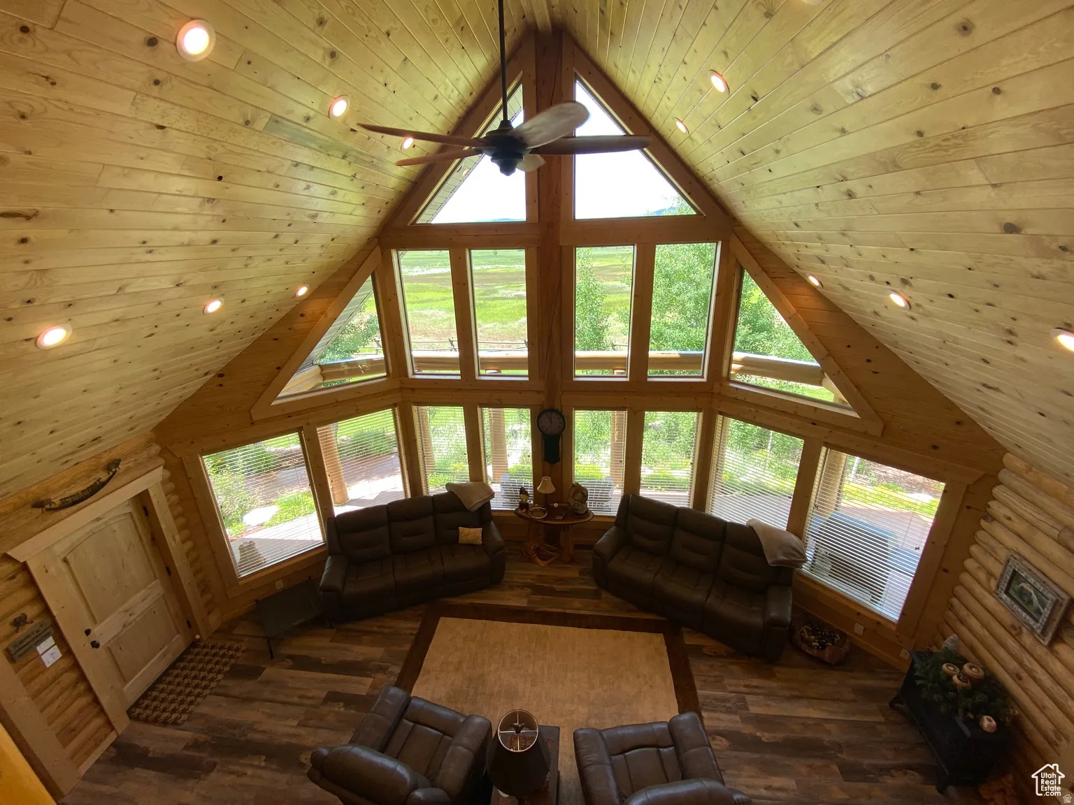 Living area with recessed lighting, a high wood ceiling, a ceiling fan, healthy amount of natural light, and dark wood-type flooring