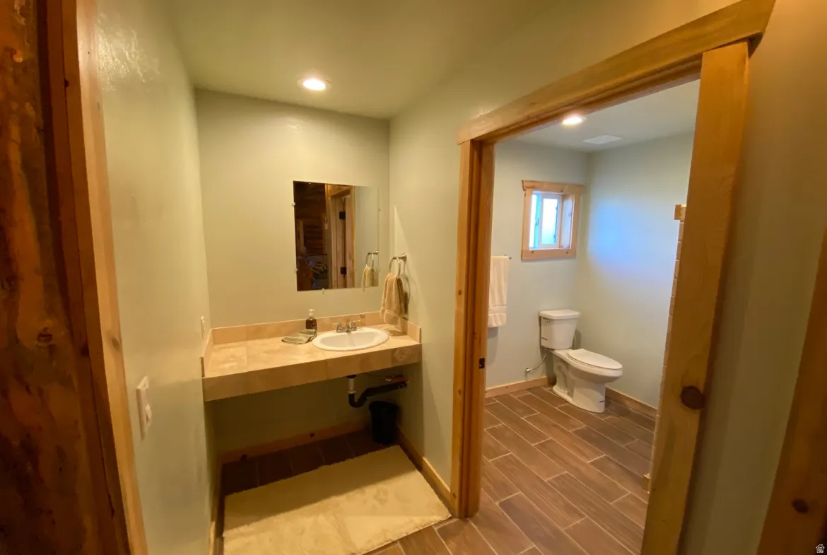 Half bath featuring recessed lighting, wood finish floors, and vanity