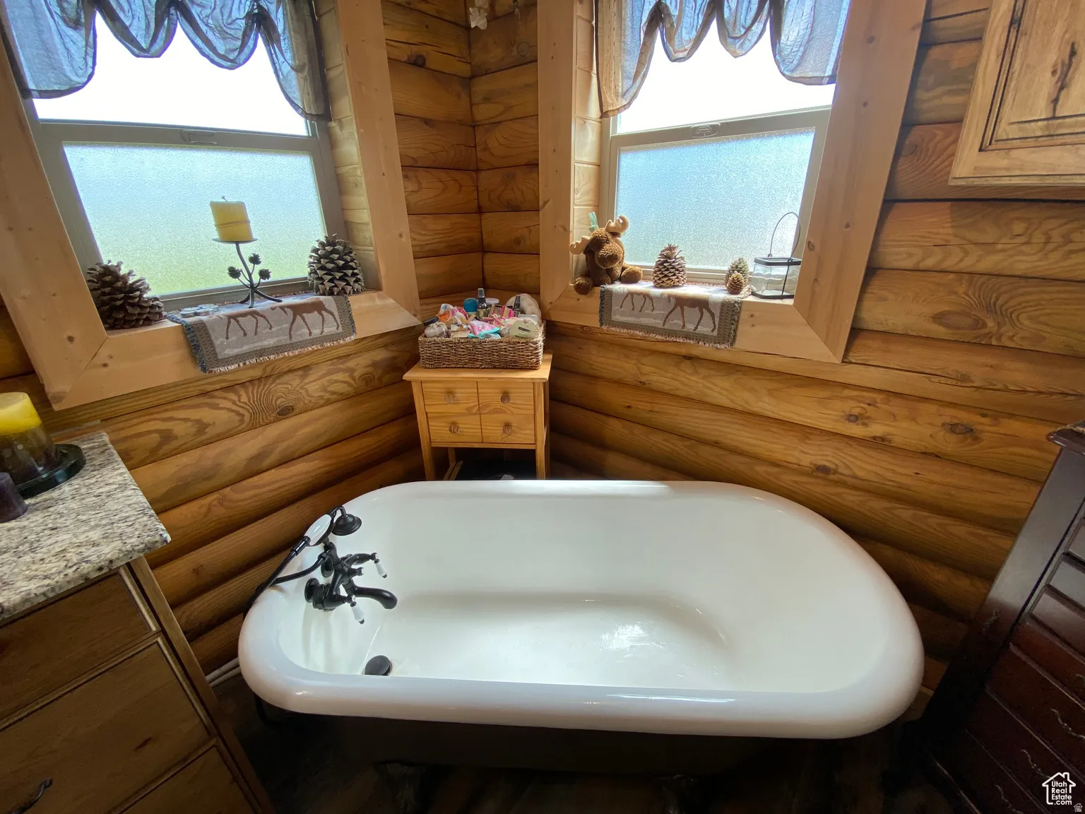 Bathroom with vanity, rustic walls, and a freestanding bath