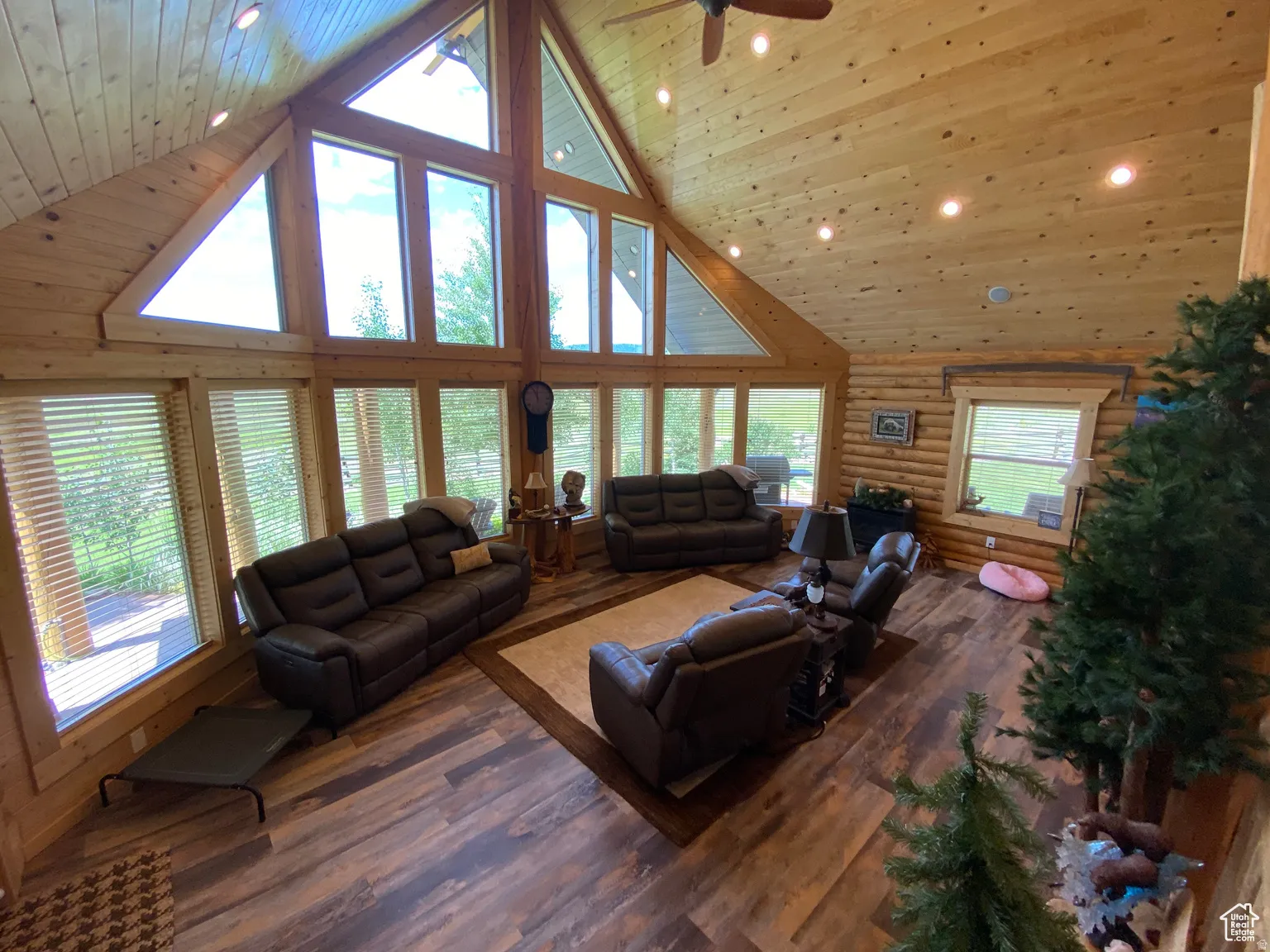 Living area with log walls, hardwood / wood-style floors, recessed lighting, a high wood ceiling, and ceiling fan