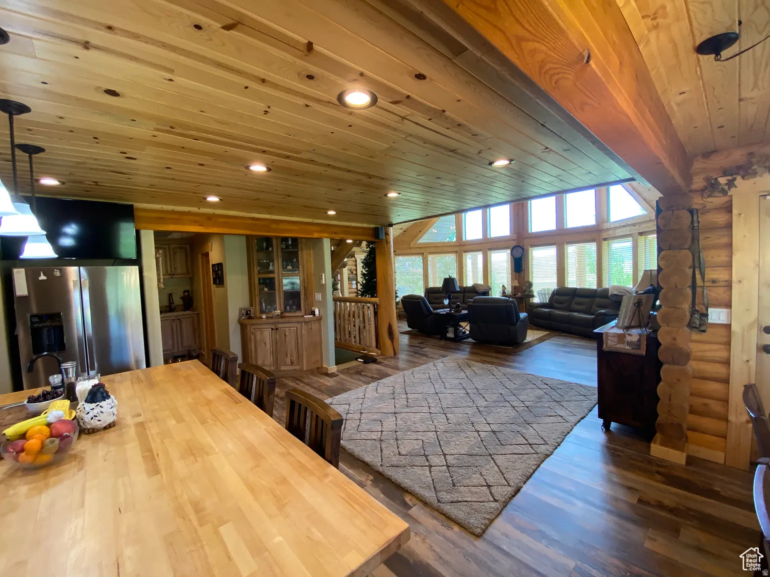 Living area featuring wood ceiling, log walls, dark wood-type flooring, and recessed lighting