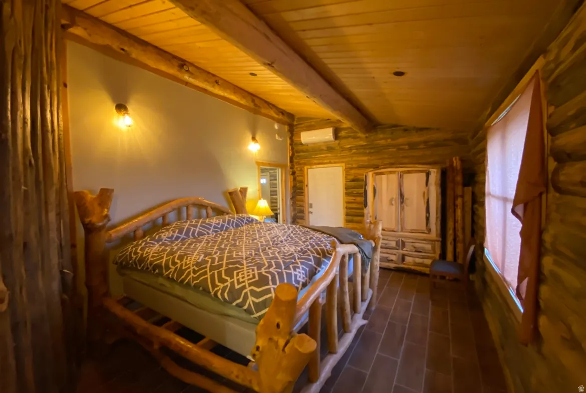 Bedroom with rustic walls, wood ceiling, lofted ceiling with beams, and dark wood-type flooring