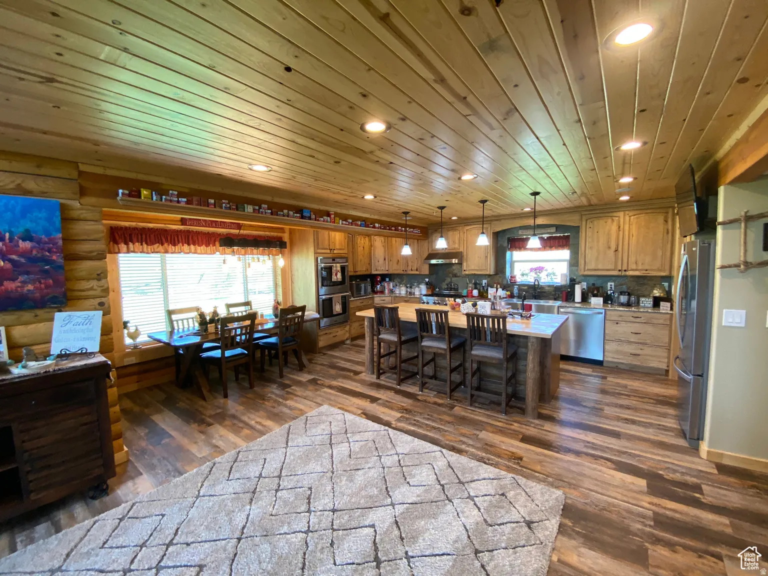 Kitchen with a center island, wood finish cabinets, stainless steel appliances, dark wood-type flooring, and wood ceiling