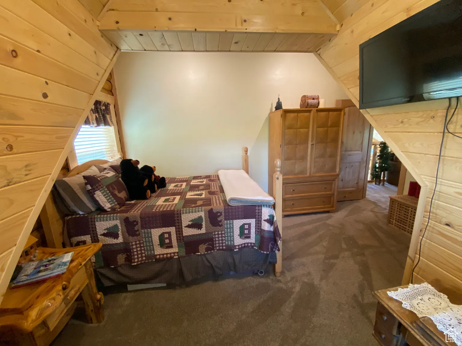 Bedroom featuring wooden ceiling, dark colored carpet, and lofted ceiling with beams