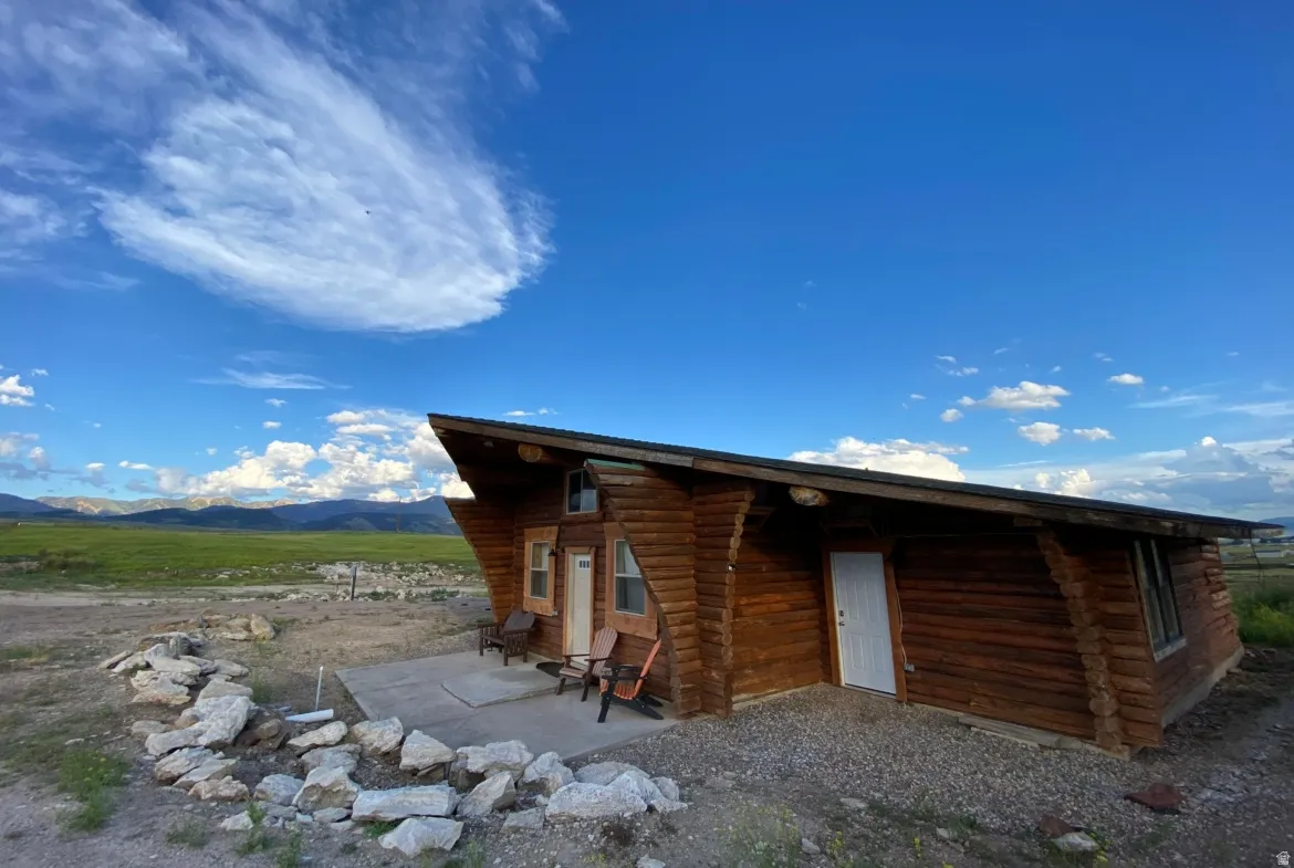View of side of home with log exterior and a mountain view