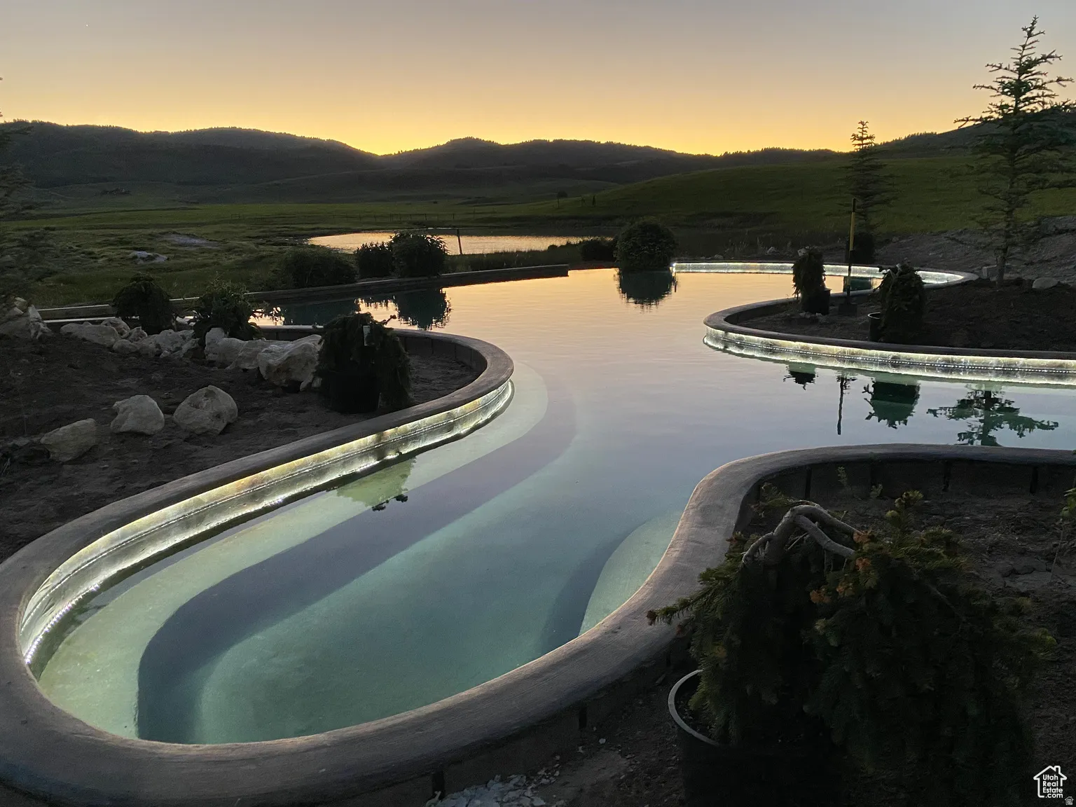 Pool at dusk with a mountain view and an infinity pool