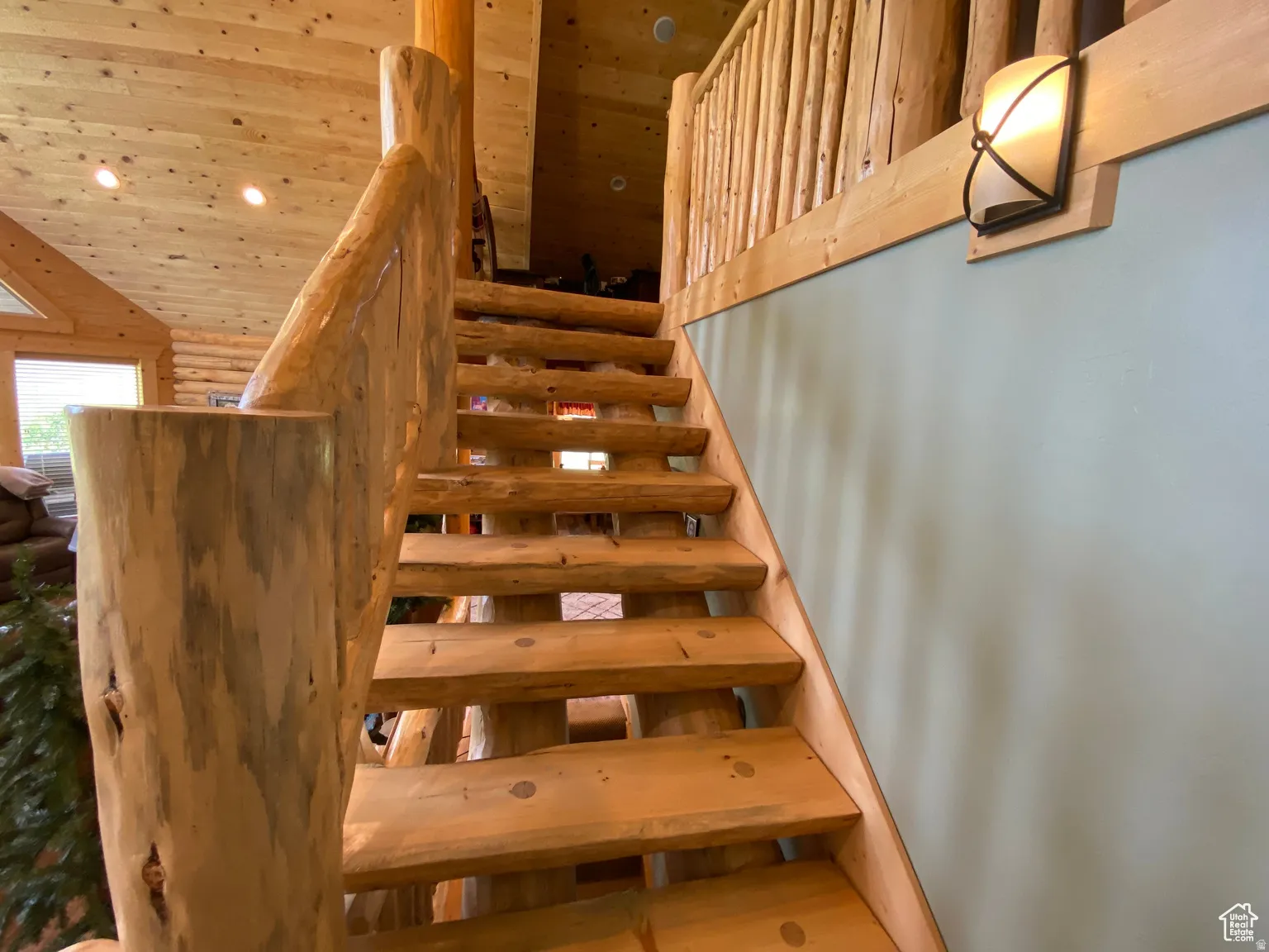 Stairway featuring wooden ceiling, recessed lighting, and rustic walls