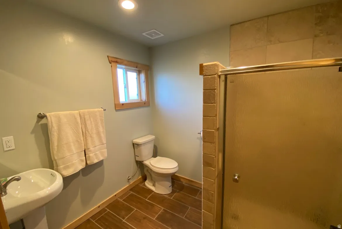 Bathroom with a shower stall and wood finish floors