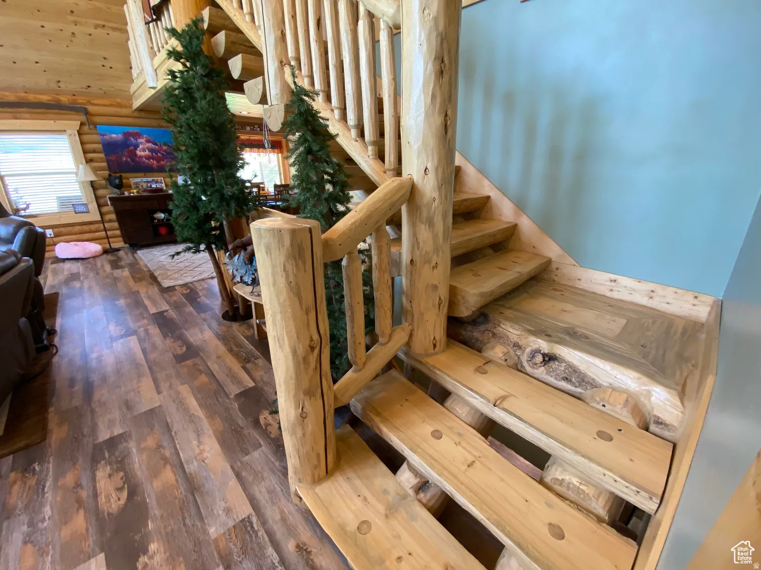 Staircase with rustic walls, hardwood / wood-style floors, and a high ceiling