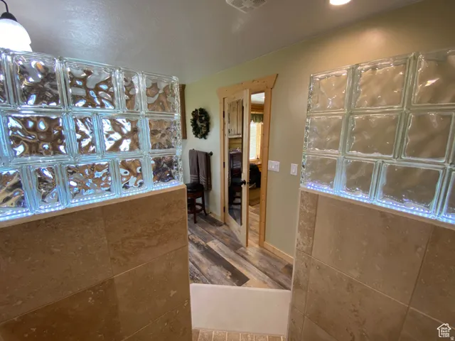 Full bath featuring dark wood-style flooring