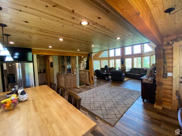 Living area featuring wood ceiling, log walls, dark wood-type flooring, and recessed lighting