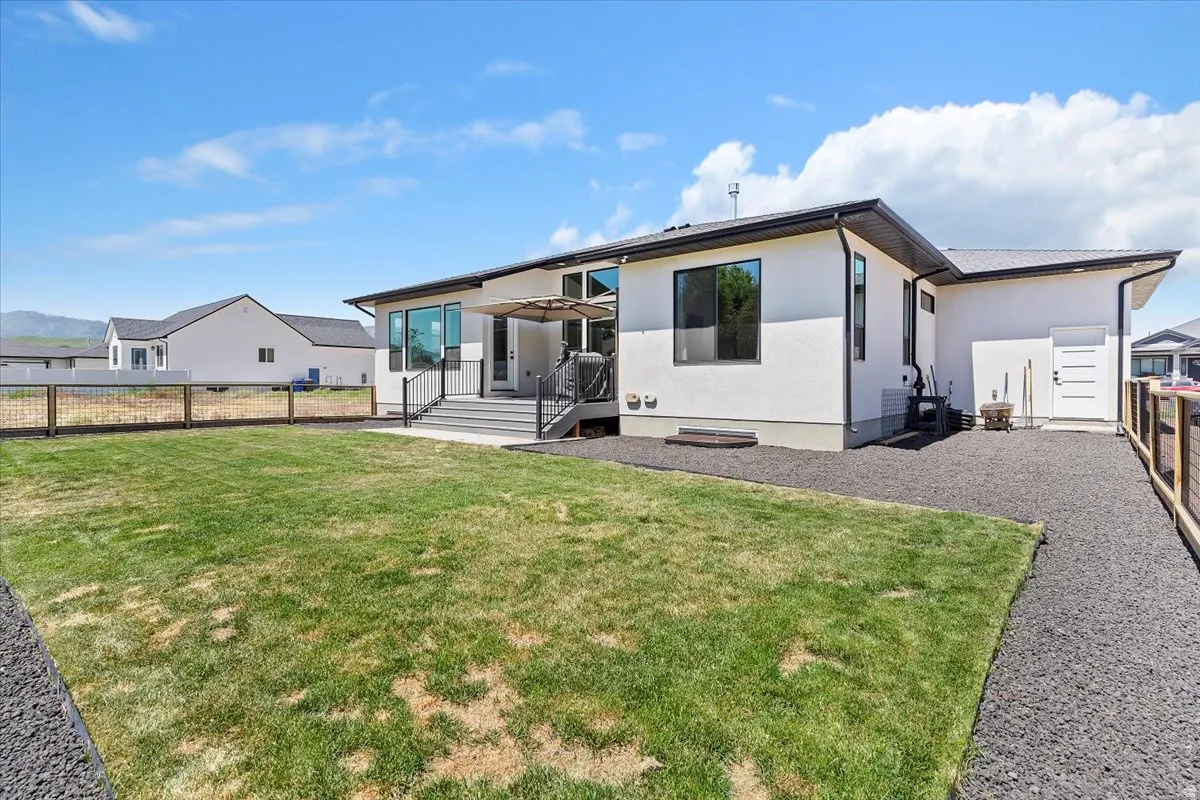 Rear view of property featuring a fenced backyard and stucco siding