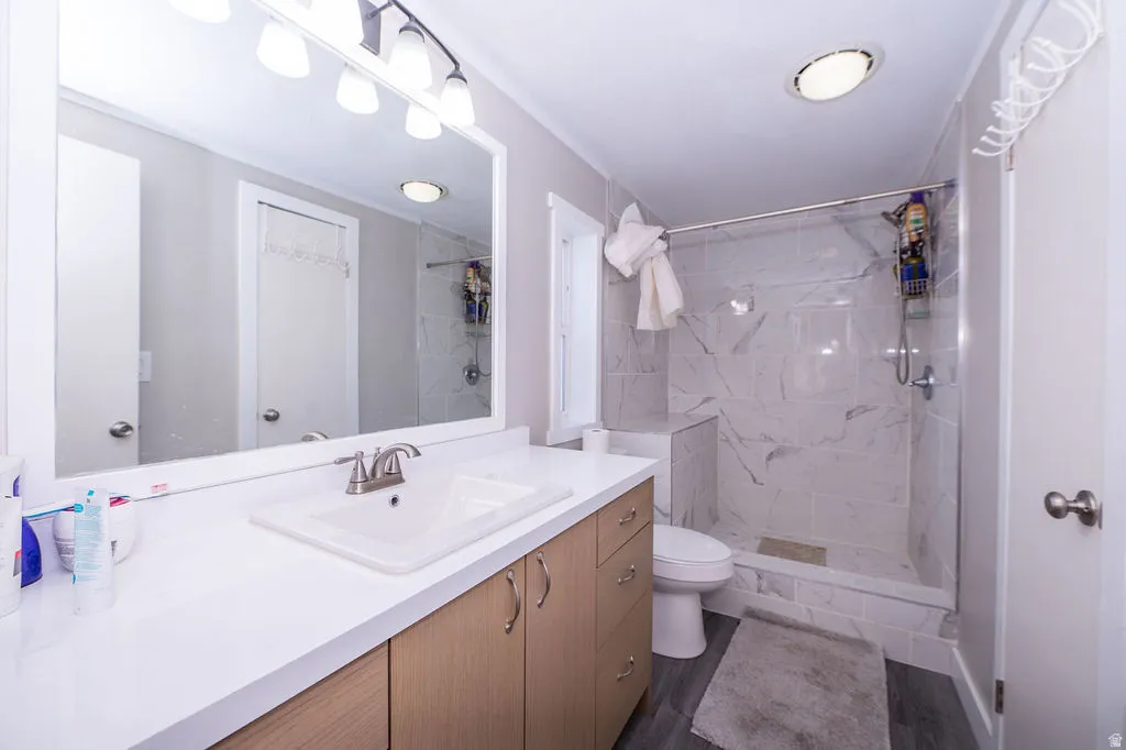 Bathroom featuring vanity and a marble finish shower