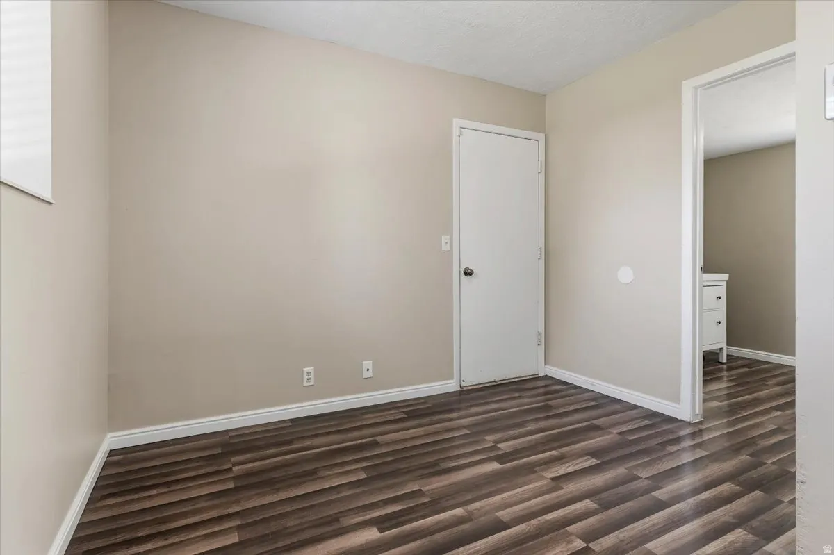 Empty Office or Family room featuring dark wood finished floors and a textured ceiling