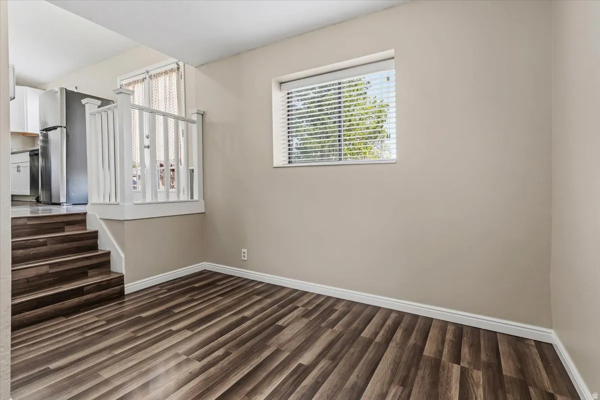 Staircase and Office or small Family Room just off Kitchen featuring wood finished floors and baseboards