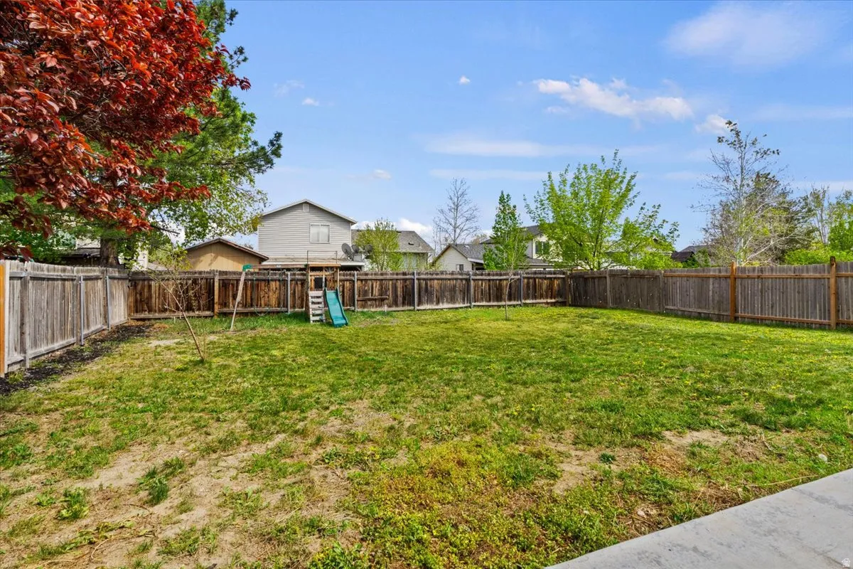 Fenced backyard featuring a residential view playground Equipment included but not warranted.