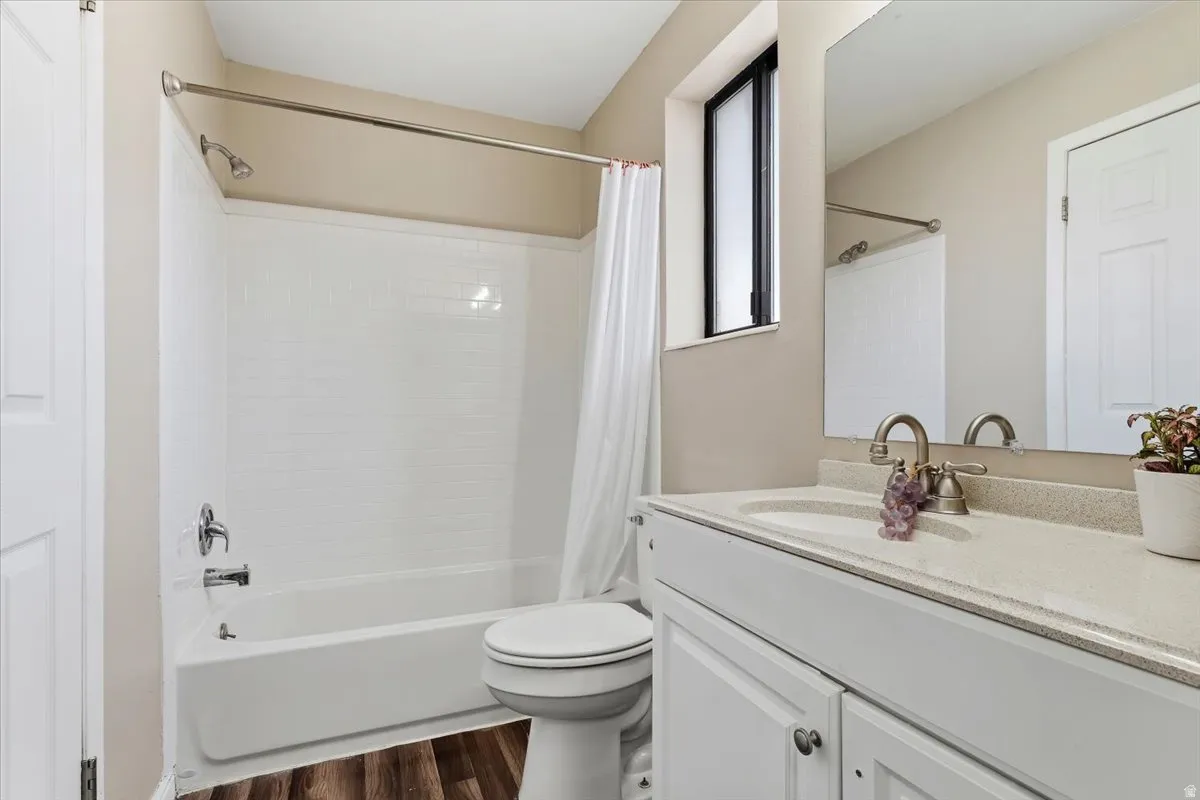 Full bathroom with New Tub Surround featuring vanity, dark wood-style floors, and shower / tub combo with curtain