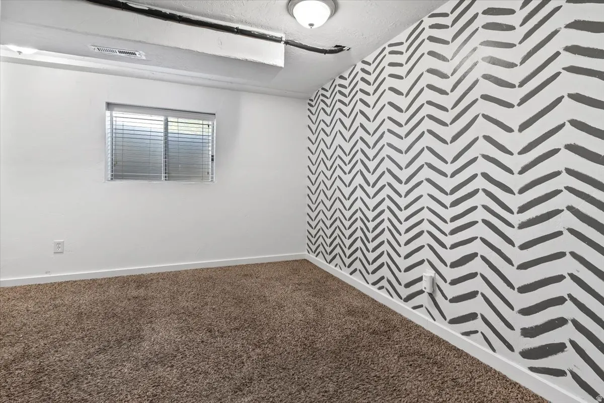 Family room with dark colored carpet and a textured ceiling