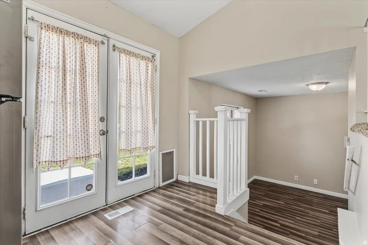 Doorway with wood finished floors and french doors to back yard. Stairs going to Office or Family Room.