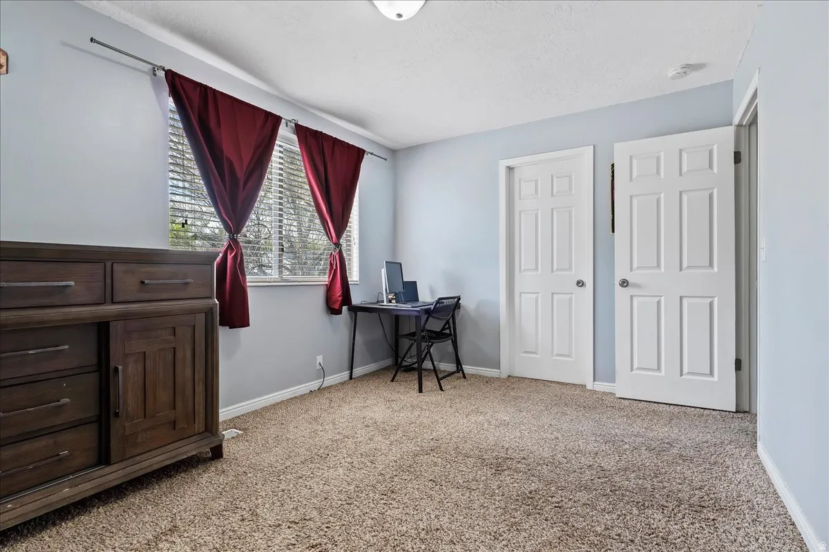 Primary Bedroom with light carpet and a textured ceiling