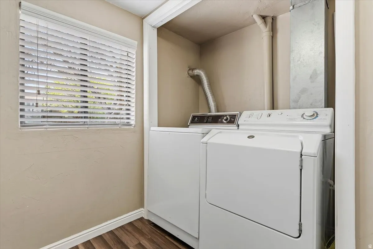 Laundry area featuring separate washer and dryer and dark wood-type flooring