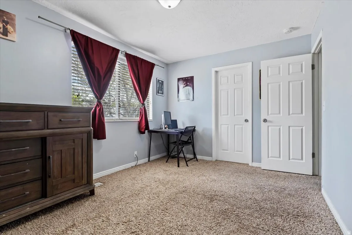 Primary Bedroom with light colored carpet and a textured ceiling
