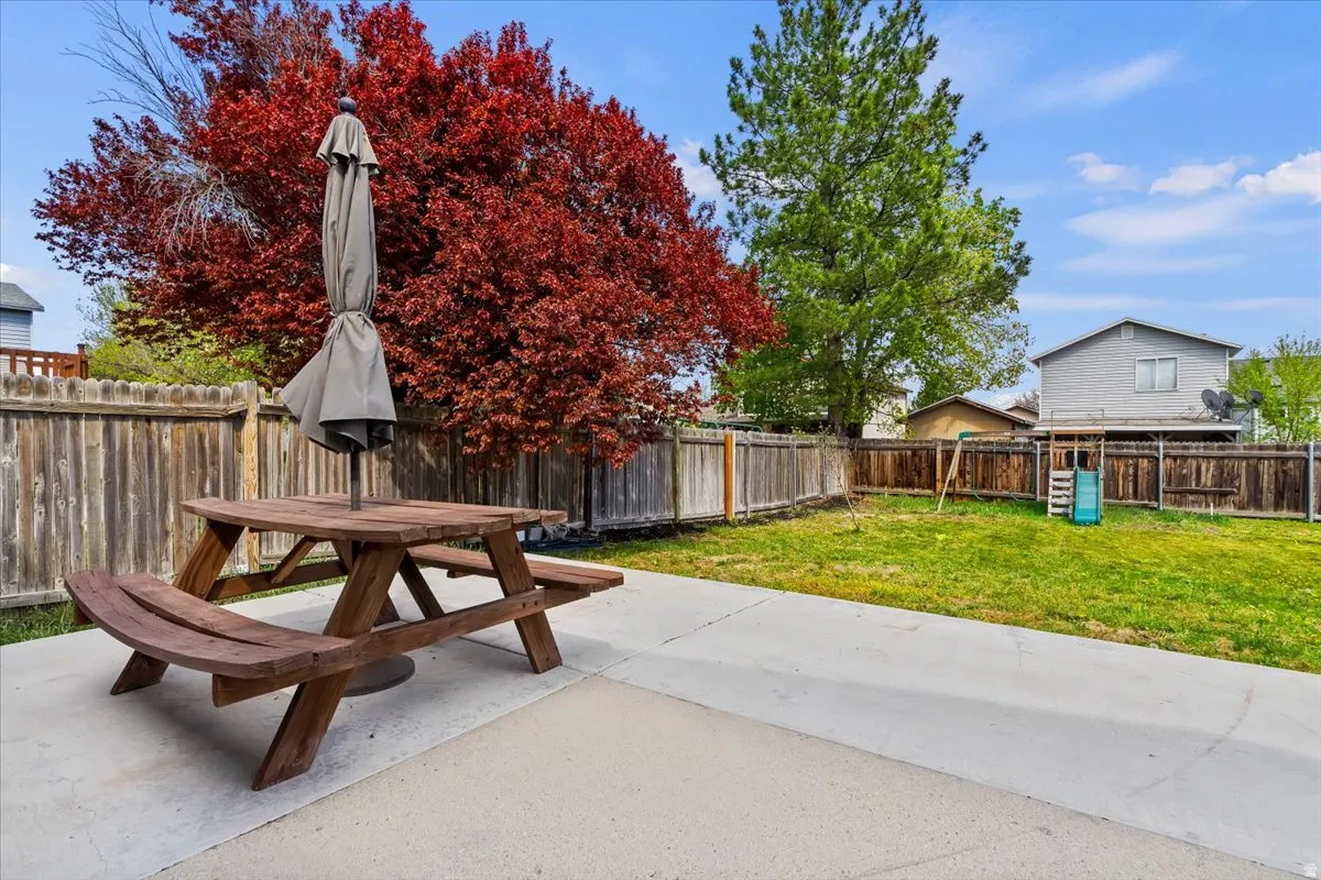 Fenced backyard with outdoor dining space and a patio area.  Picnic table included and umbrella included.