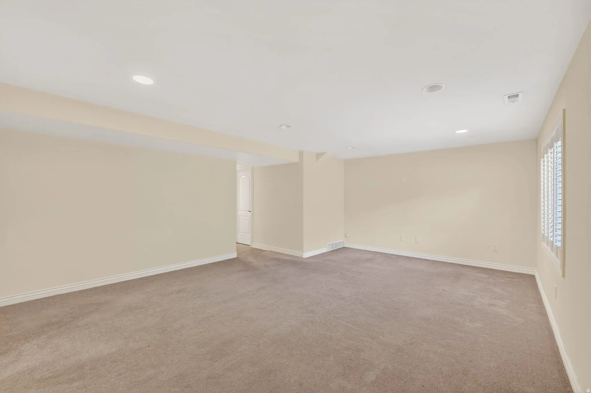 Spare room featuring light carpet and recessed lighting