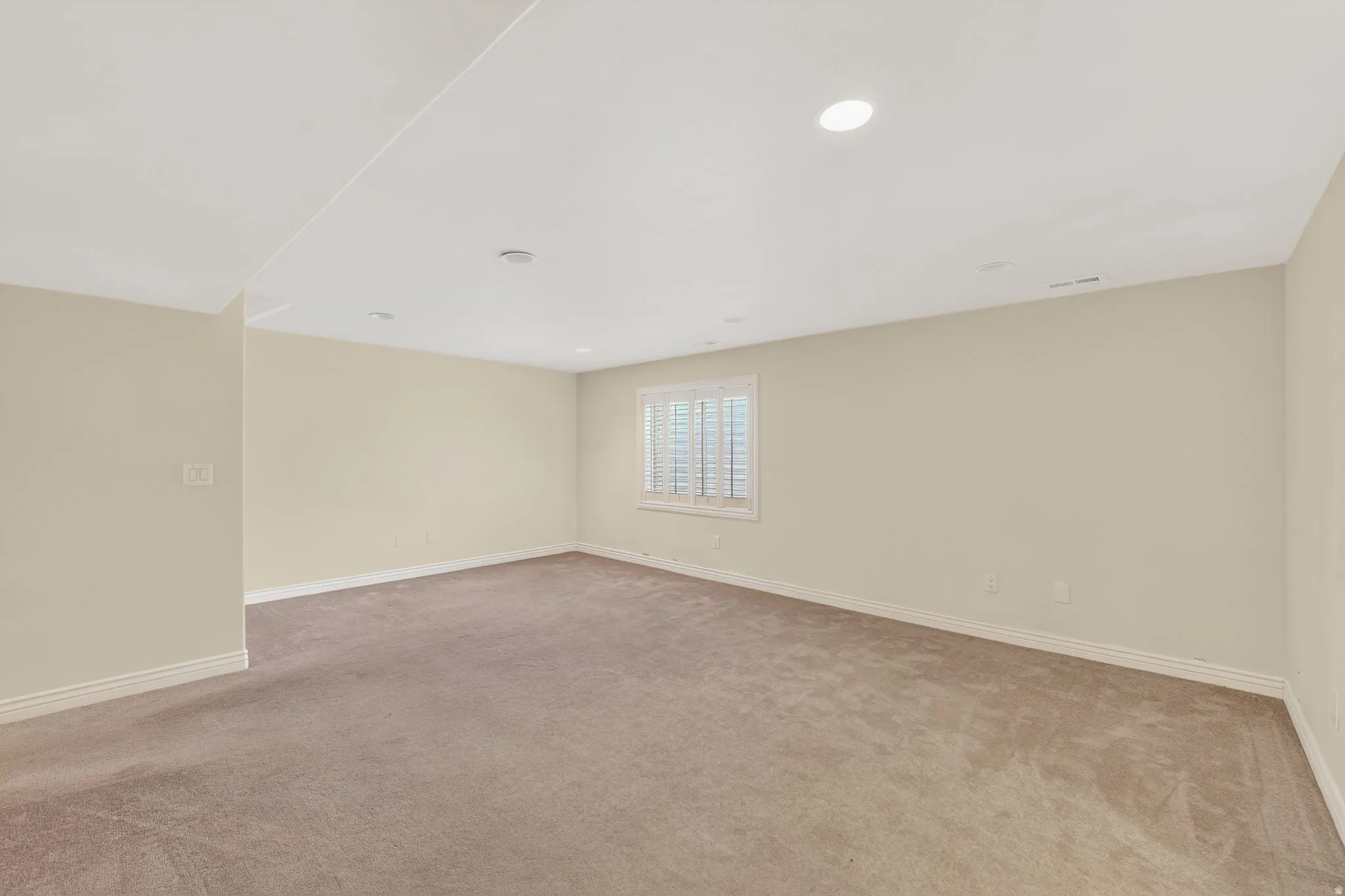Unfurnished room with light colored carpet and recessed lighting