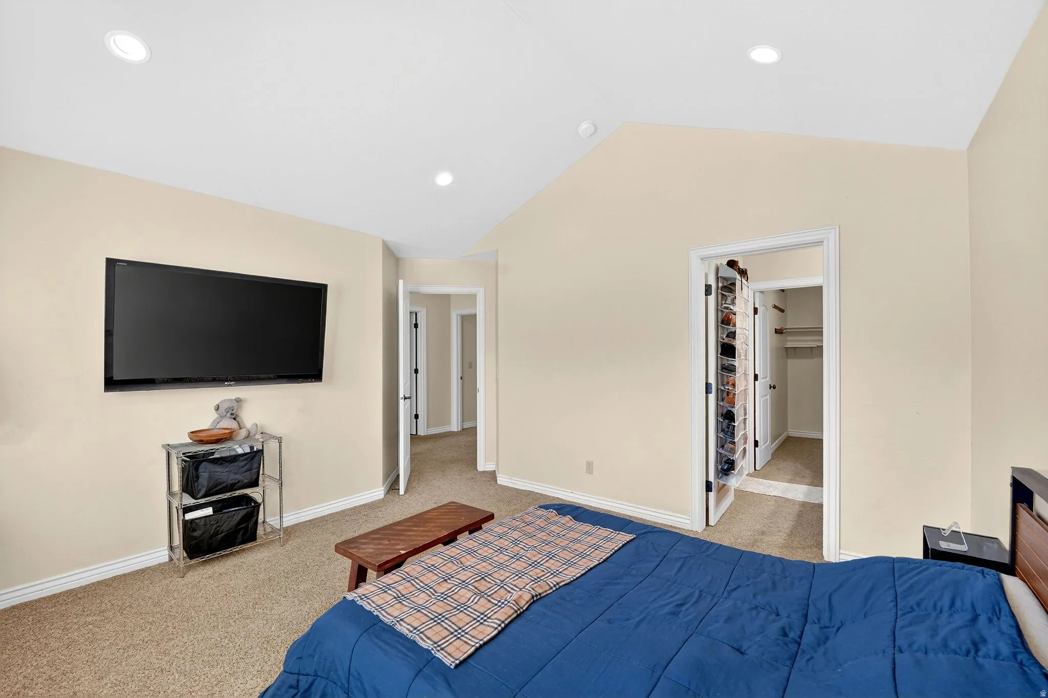Bedroom with light colored carpet, a spacious closet, and recessed lighting