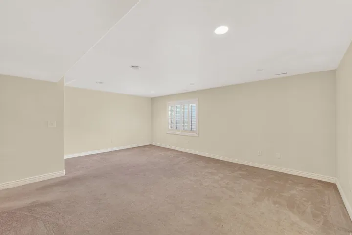 Unfurnished room with light colored carpet and recessed lighting