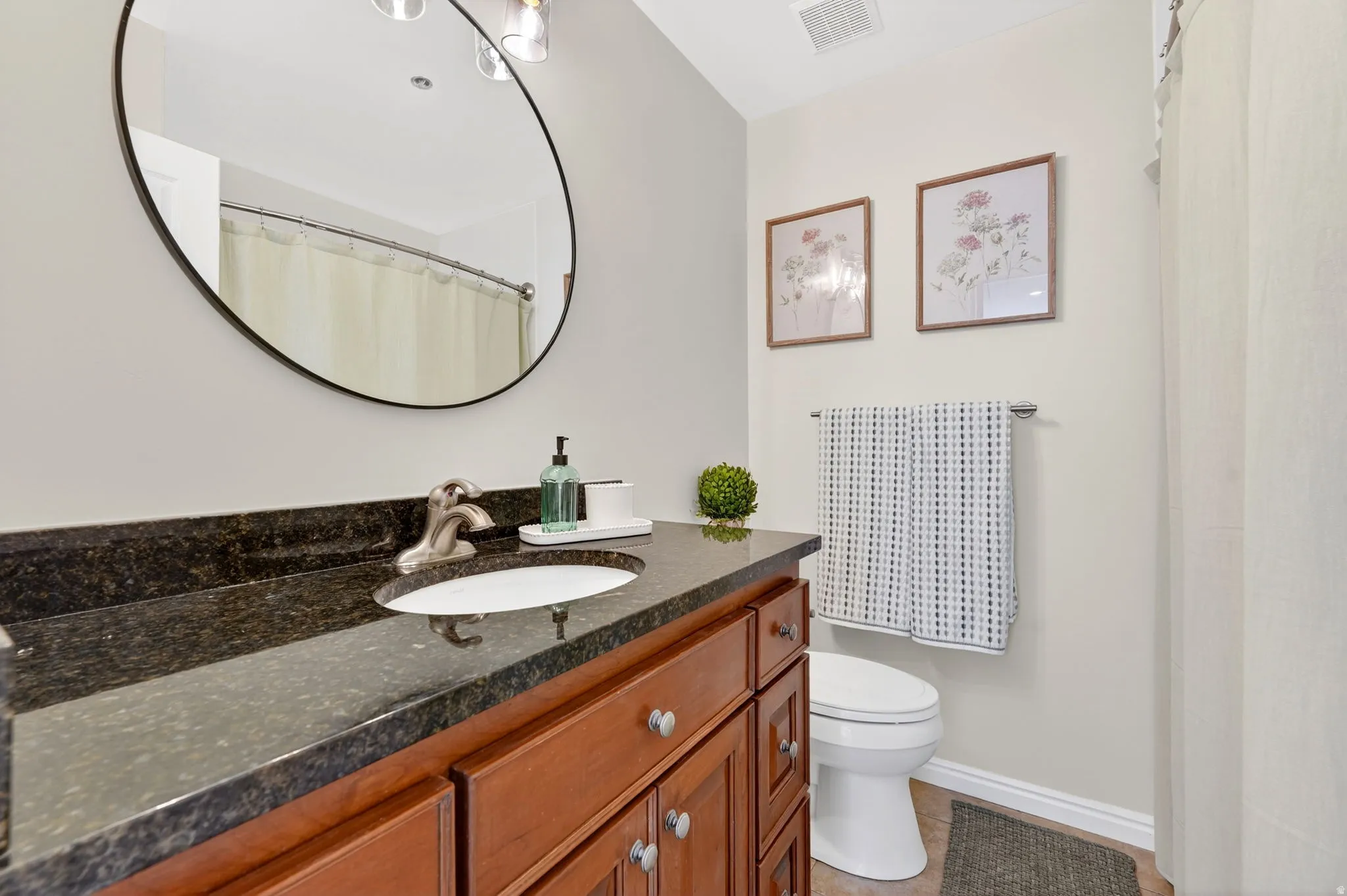 Full size bathroom featuring granite counter tops and tiling.