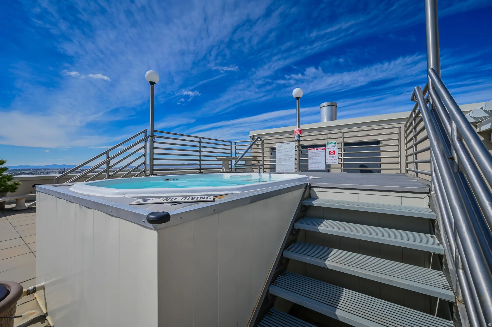 Rooftop hot tub with city and mountain views.