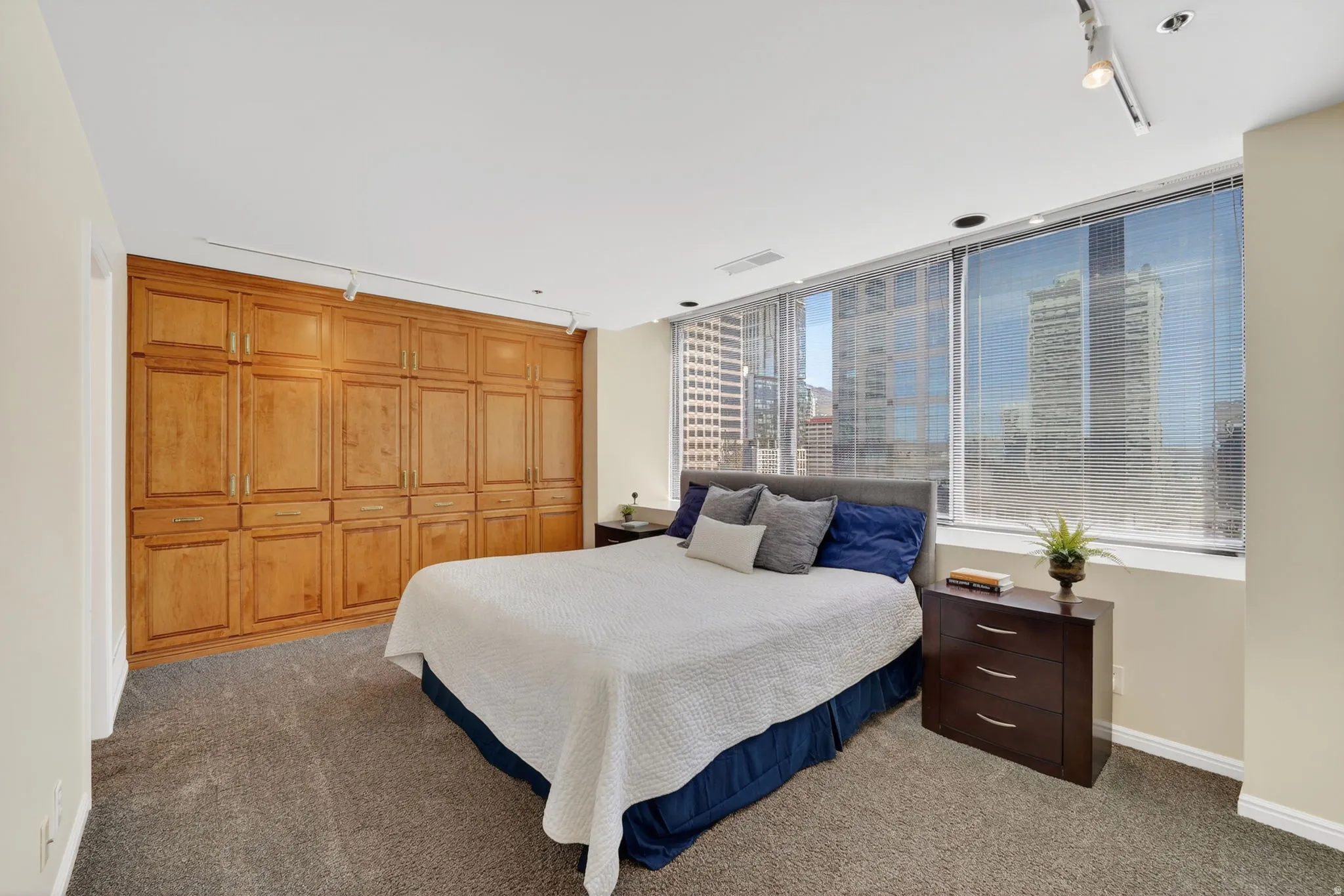 Bedroom with track lighting, built in's for storage, East facing windows with natural lighting.