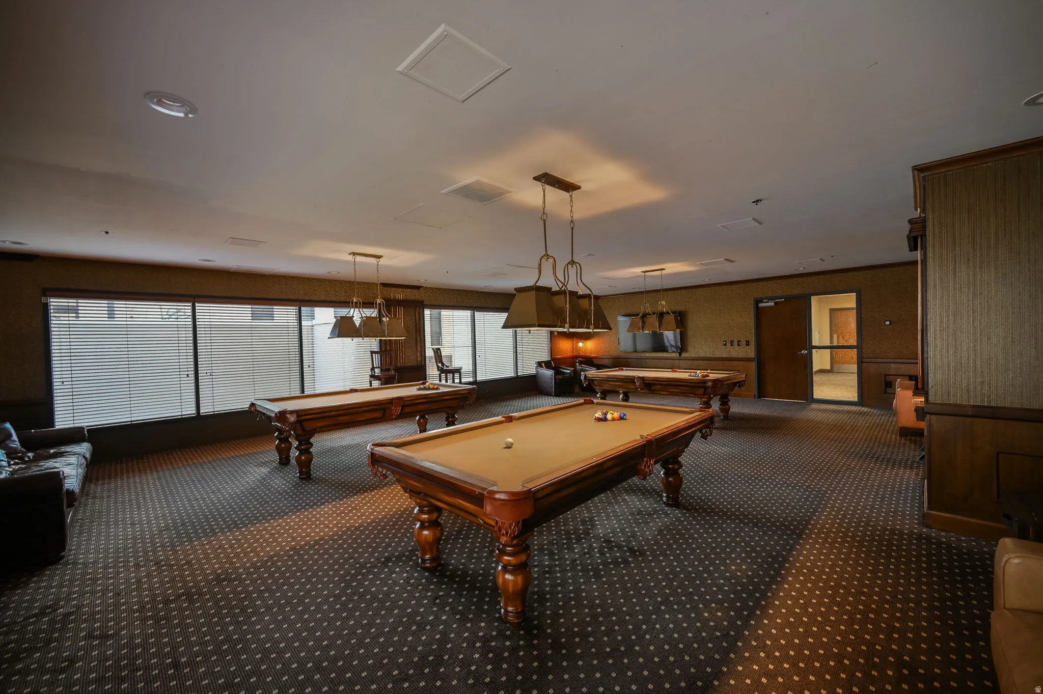 Community recreation room with pool tables, tv's and seating for entertaining.