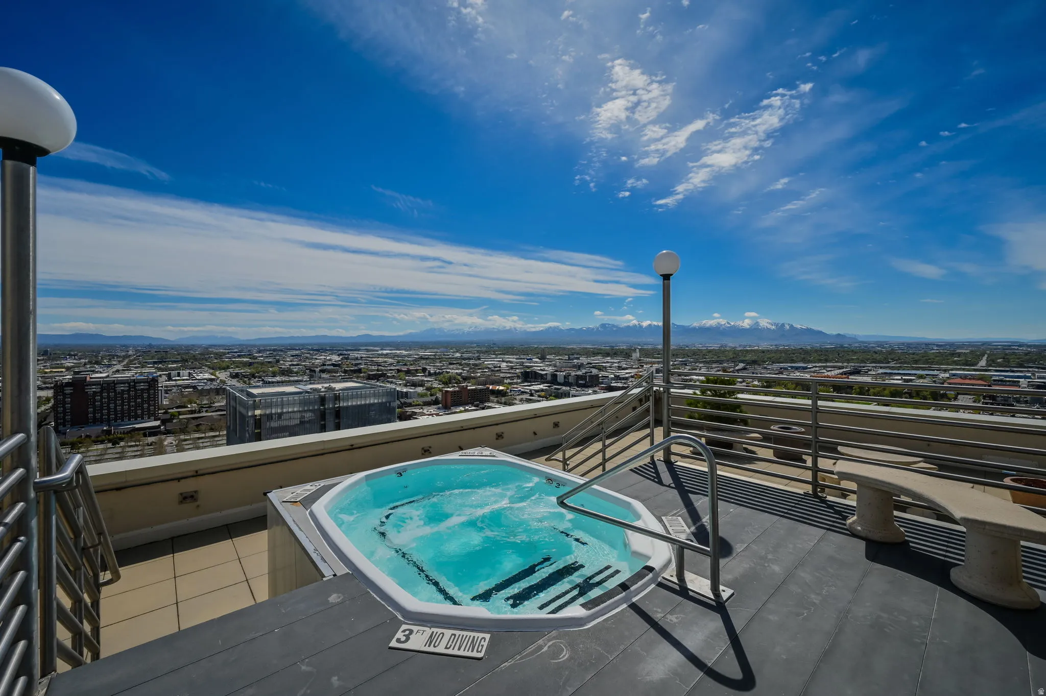Rooftop hot tub with city and mountain views.