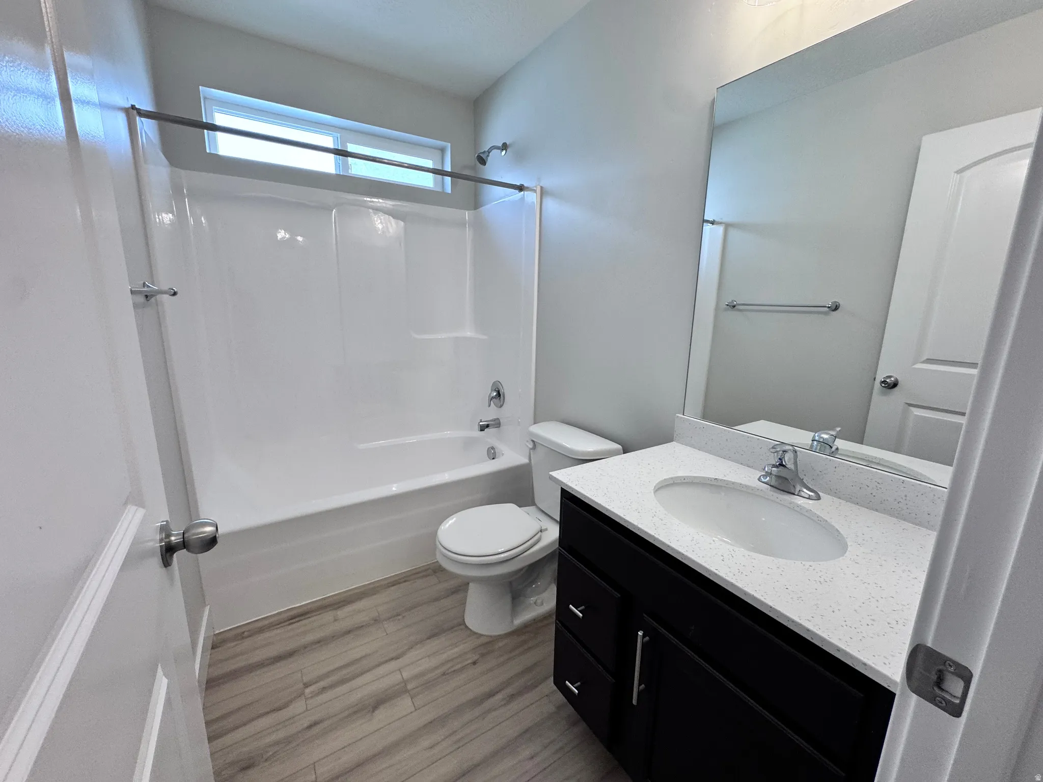 Full bathroom featuring vanity, bathtub / shower combination, and light wood-type flooring