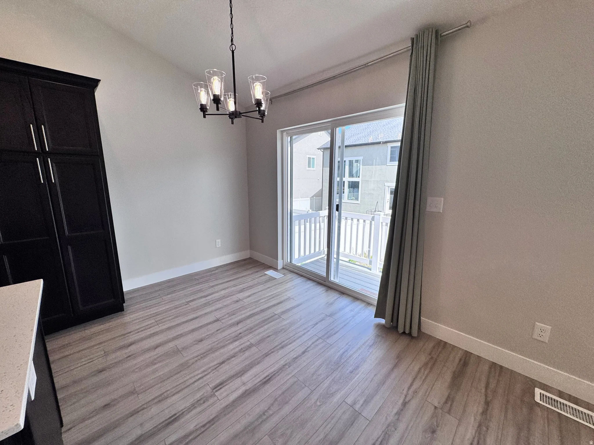 Unfurnished dining area featuring hanging lights, lofted ceiling, and light wood-type flooring