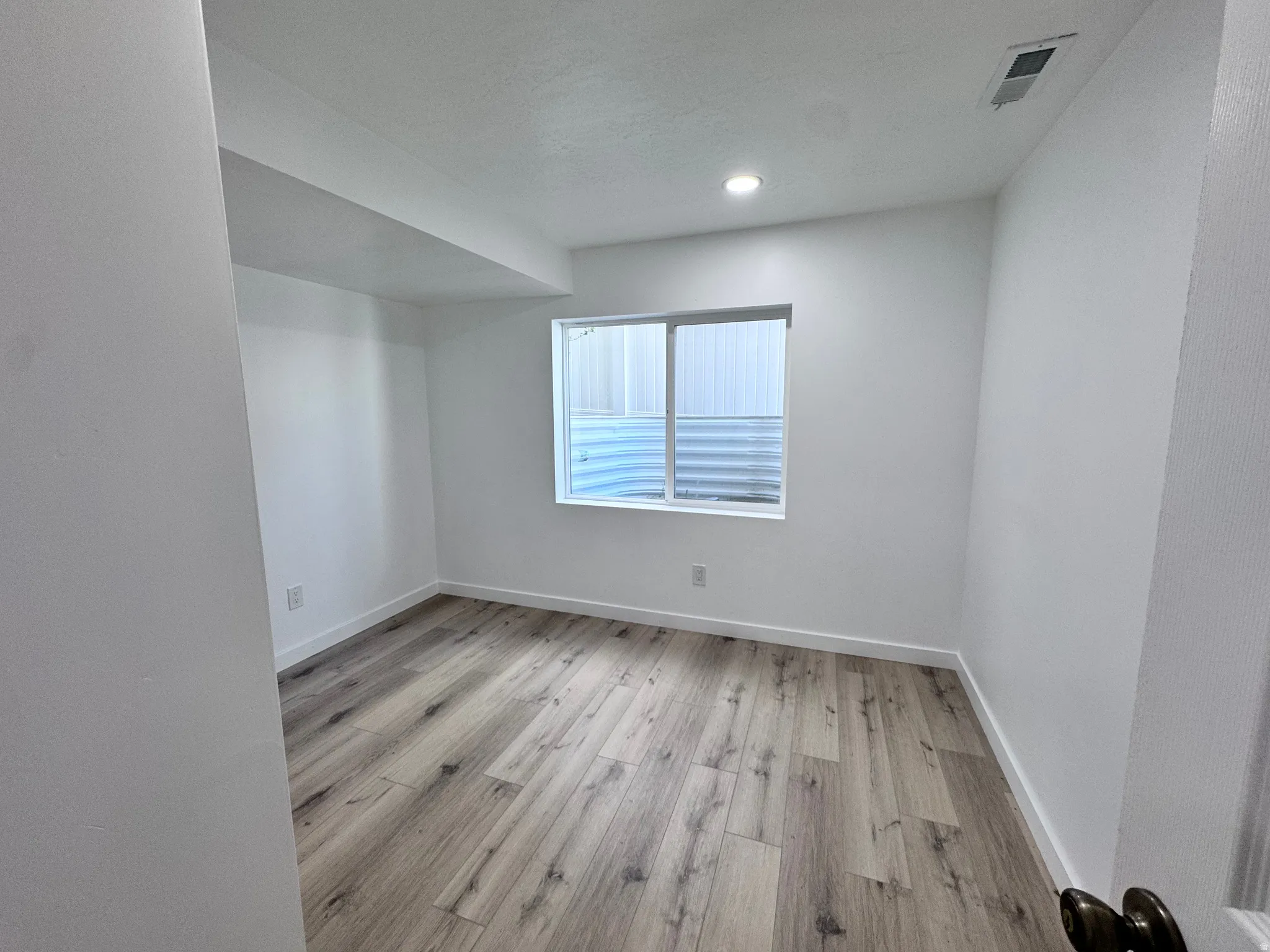 Unfurnished room featuring light wood finished floors and baseboards
