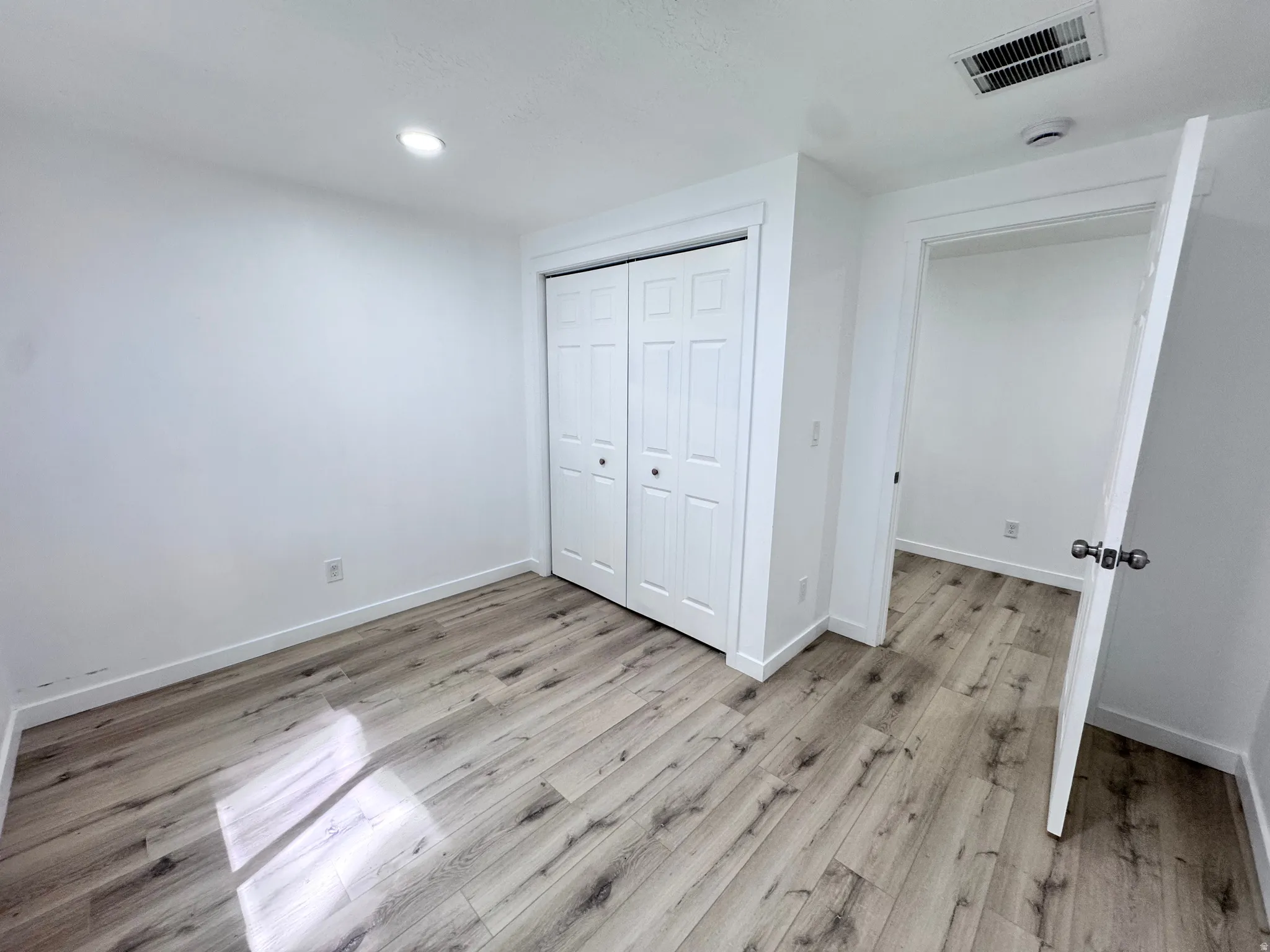 Unfurnished bedroom featuring a closet, light wood-type flooring, and recessed lighting