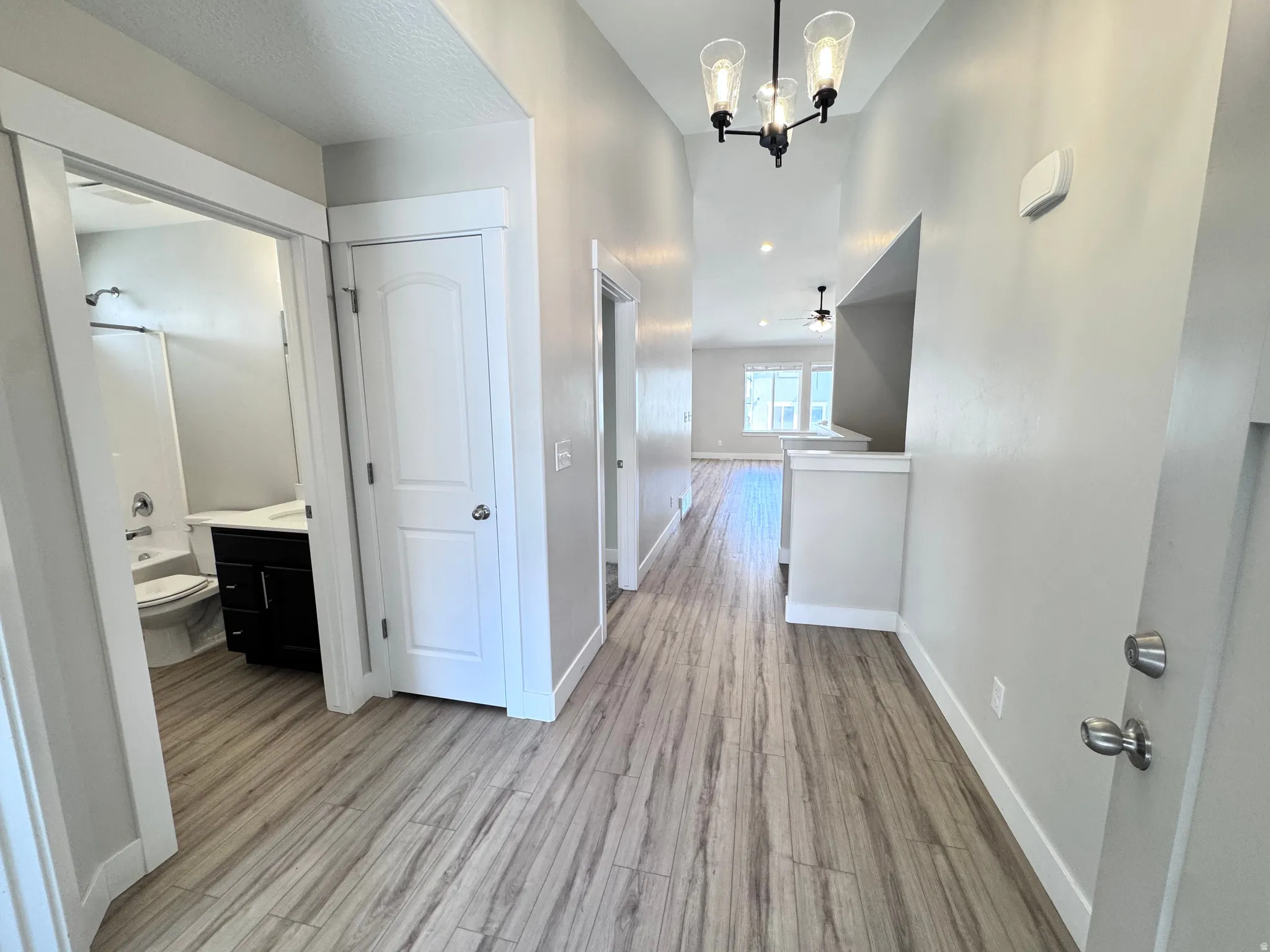 Hall featuring light wood-style floors and hanging lights