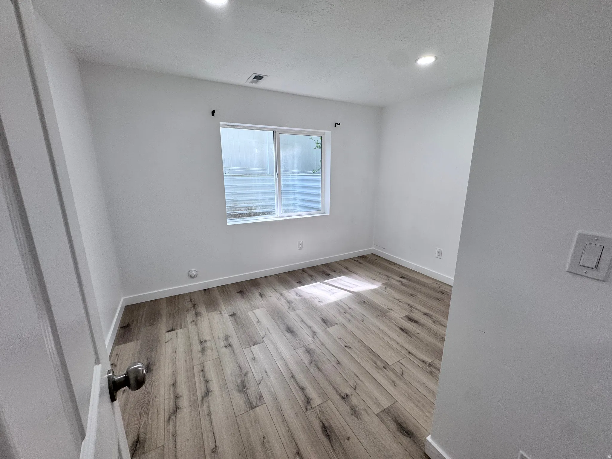 Unfurnished room with light wood-style floors and recessed lighting