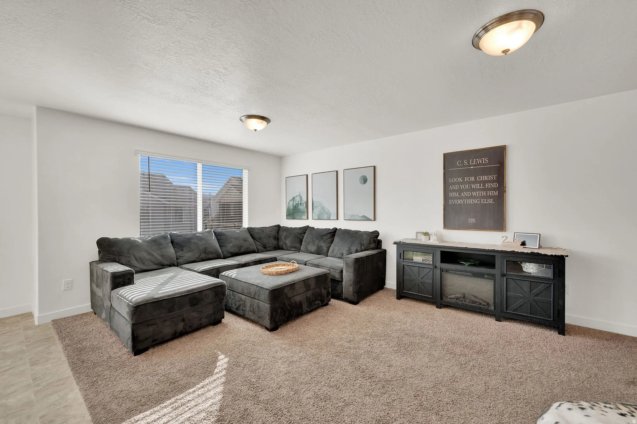 Living room with a textured ceiling and light colored carpet