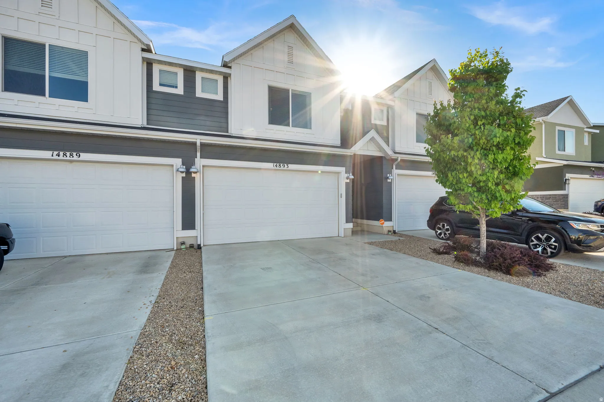 View of front of property with a garage, concrete driveway, and board and batten siding