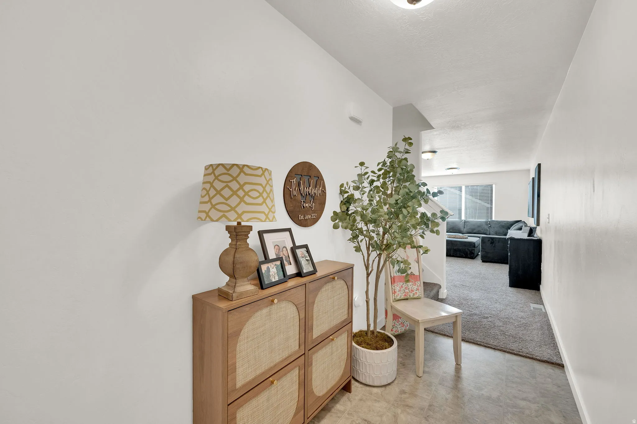 Corridor with light colored carpet and baseboards
