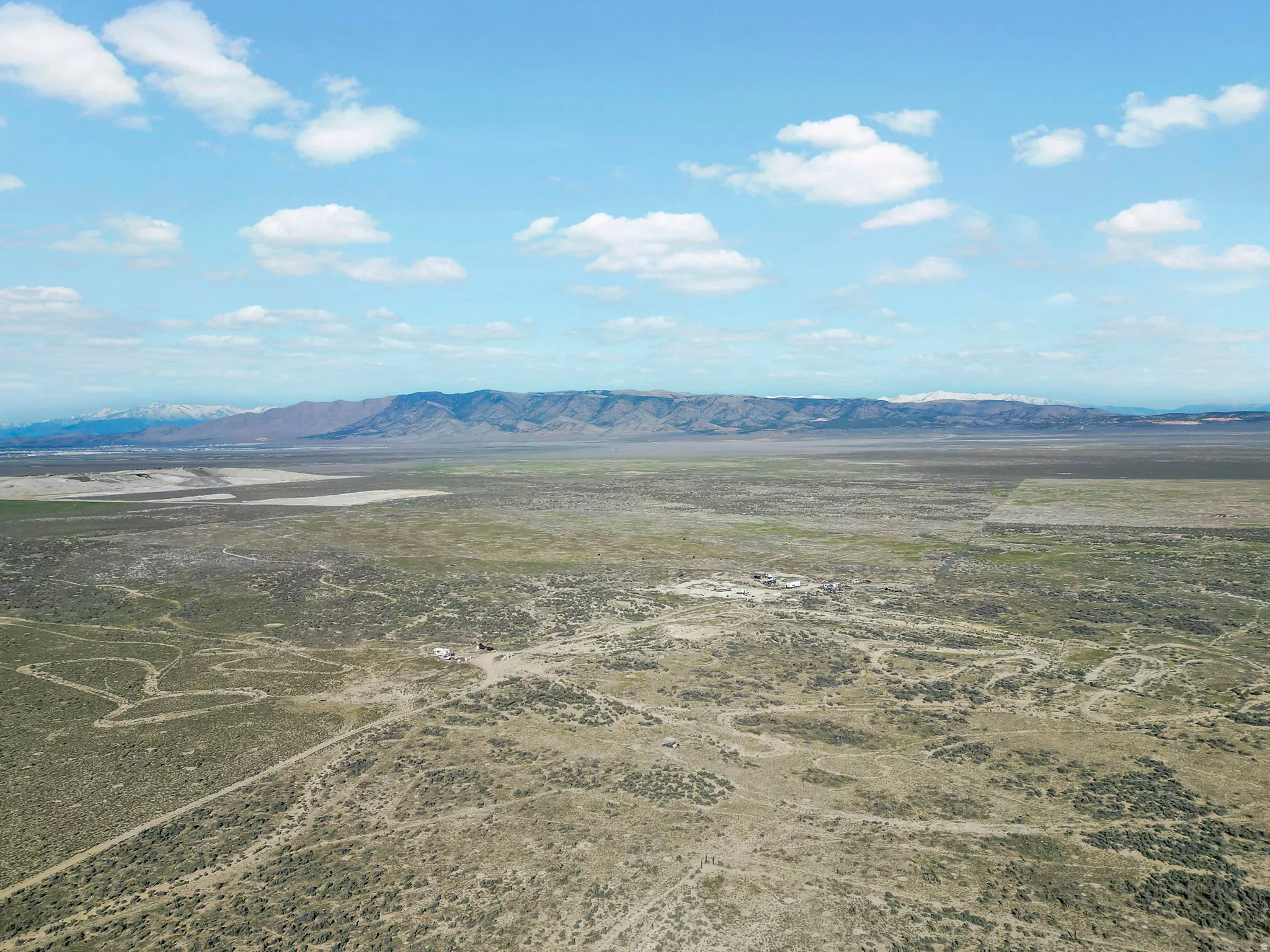 Expansive desert landscape with natural vegetation and distant snow-capped mountains