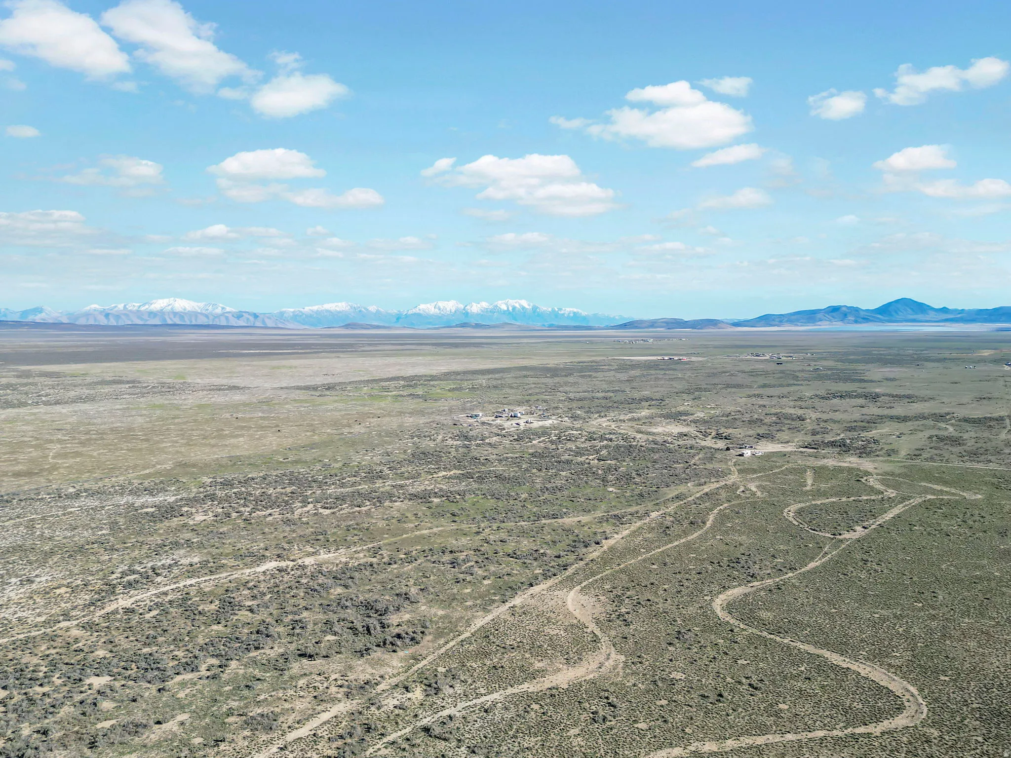 Expansive undeveloped acreage featuring natural scrub brush vegetation and a distant mountain range backdrop